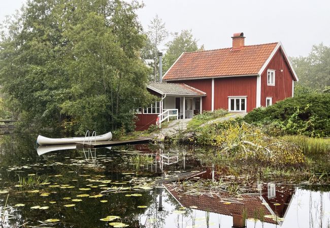 Stuga i Fårbo - Röd stuga belägen vid en kvarndamm och sjö utanför Fårbo I SE05050
